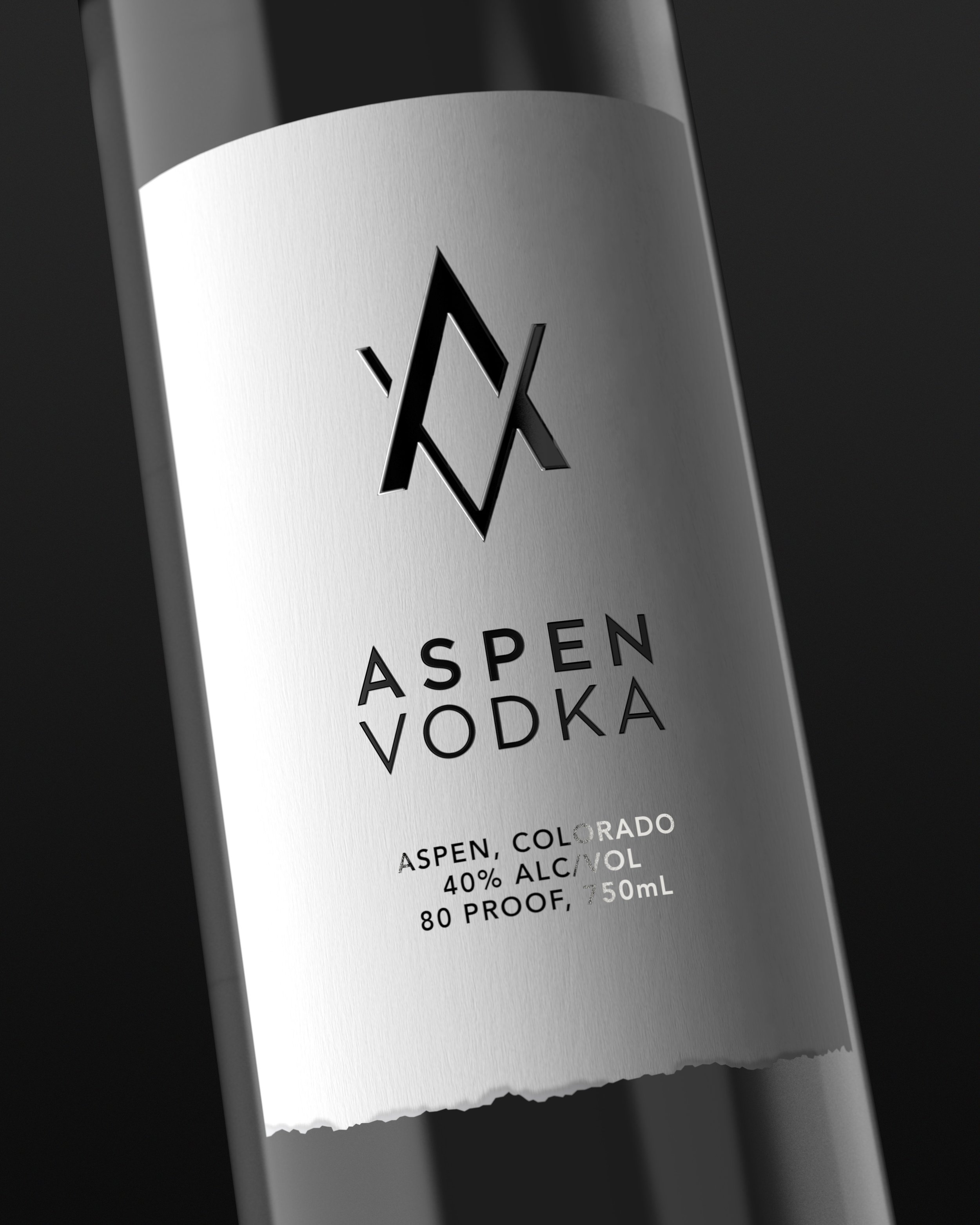 Close-up of a metal bottle with a black logo featuring an 'A' and a diamond shape, and the words 'ASPEN, COLORADO' and 'VODKA' printed below, on a dark background.