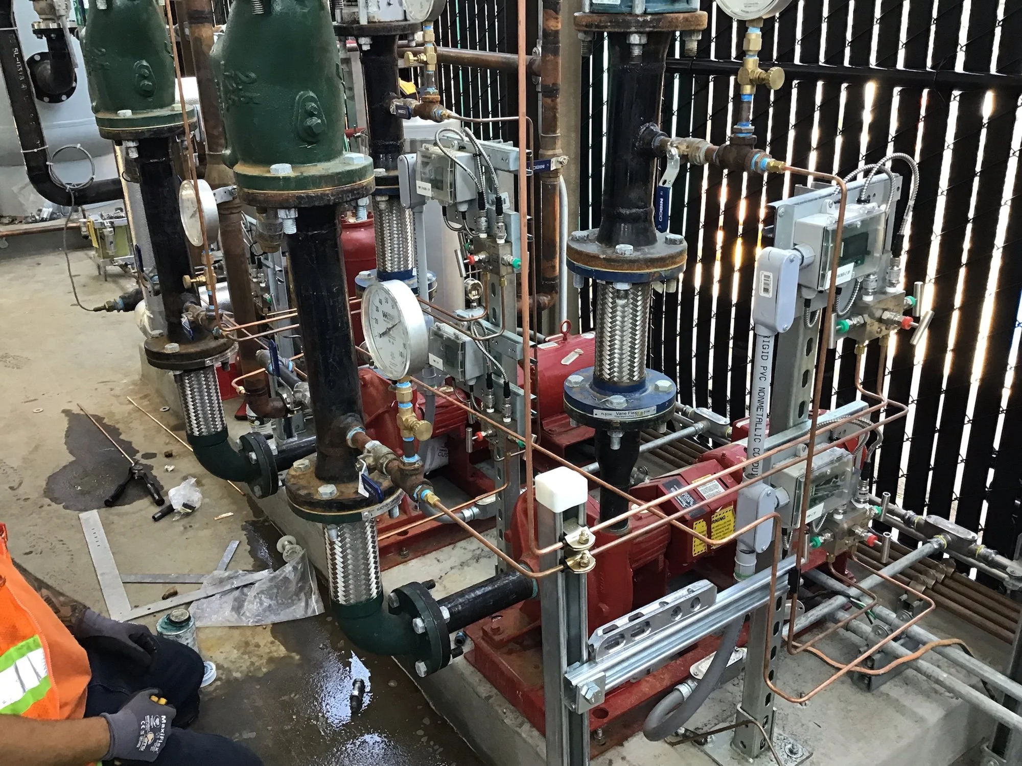 Industrial piping system with valves, gauges, and control units in a construction or maintenance setting.