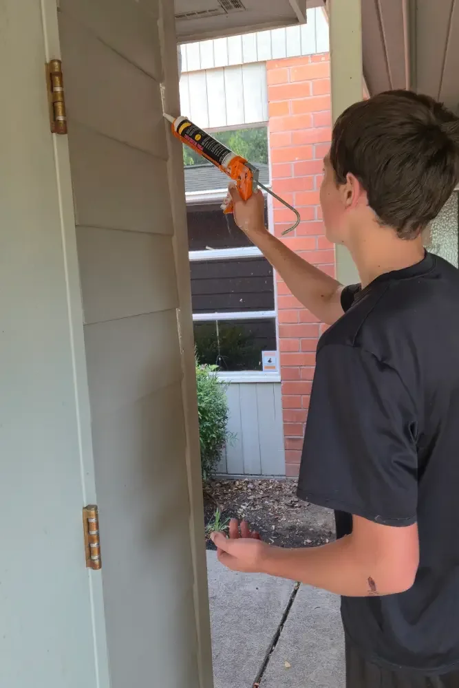 A teenager holds a caulking tool at Calvin Presbyterian Church.