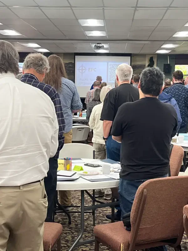 People standing in a room in front of a screen.