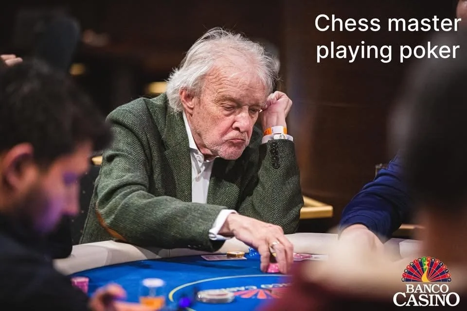 An elderly man with gray hair and a beard wearing a green jacket playing poker at a casino table, with the caption "Chess master playing poker" in the upper right corner, and the Banco Casino logo in the bottom right corner.