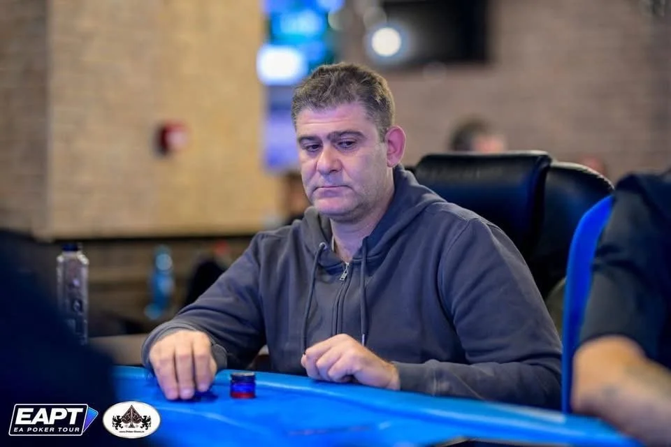 A man sitting at a poker table, focused on the game, with poker chips in front of him.