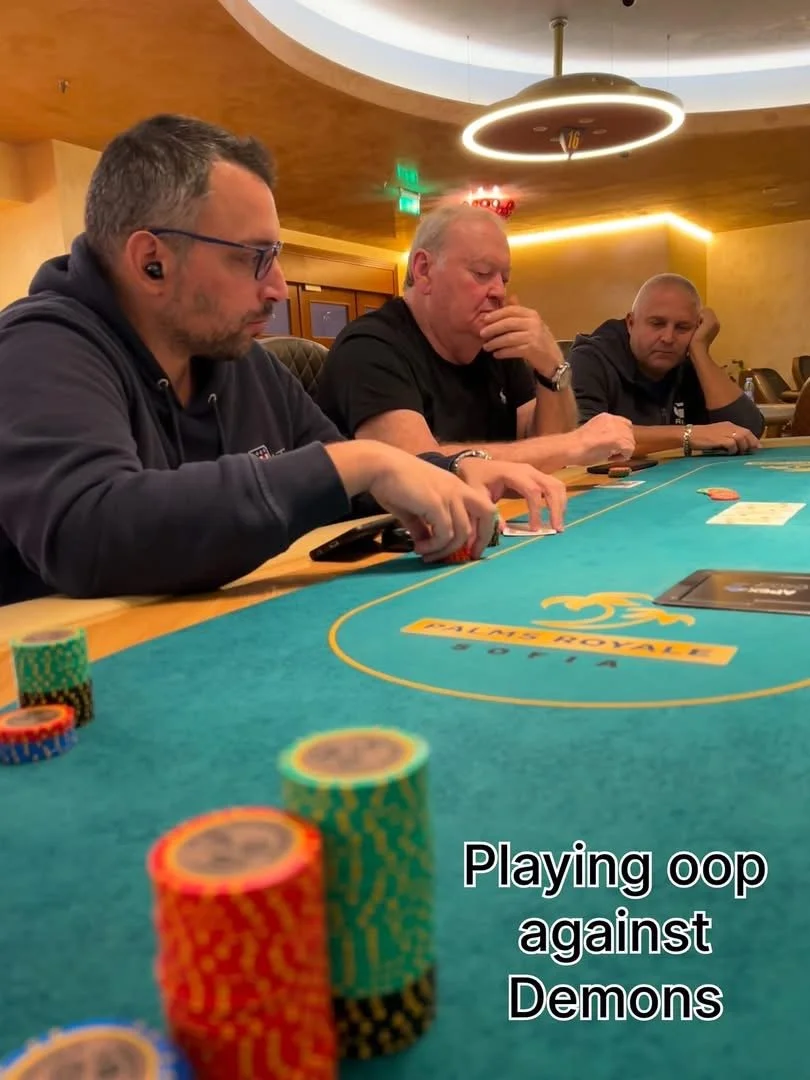 Three men sitting at a poker table, focused on their game in a casino setting, with poker chips and cards on the table. The caption reads "Playing oop against Demons."