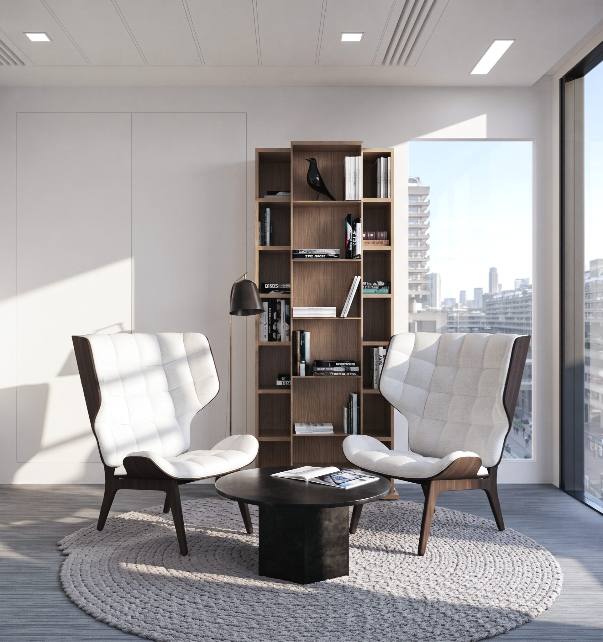 A modern office lounge area with two white upholstered chairs around a black round coffee table, a built-in wooden bookshelf with decorative items and books, a black floor lamp, a textured circular beige rug, and large windows with a city skyline view