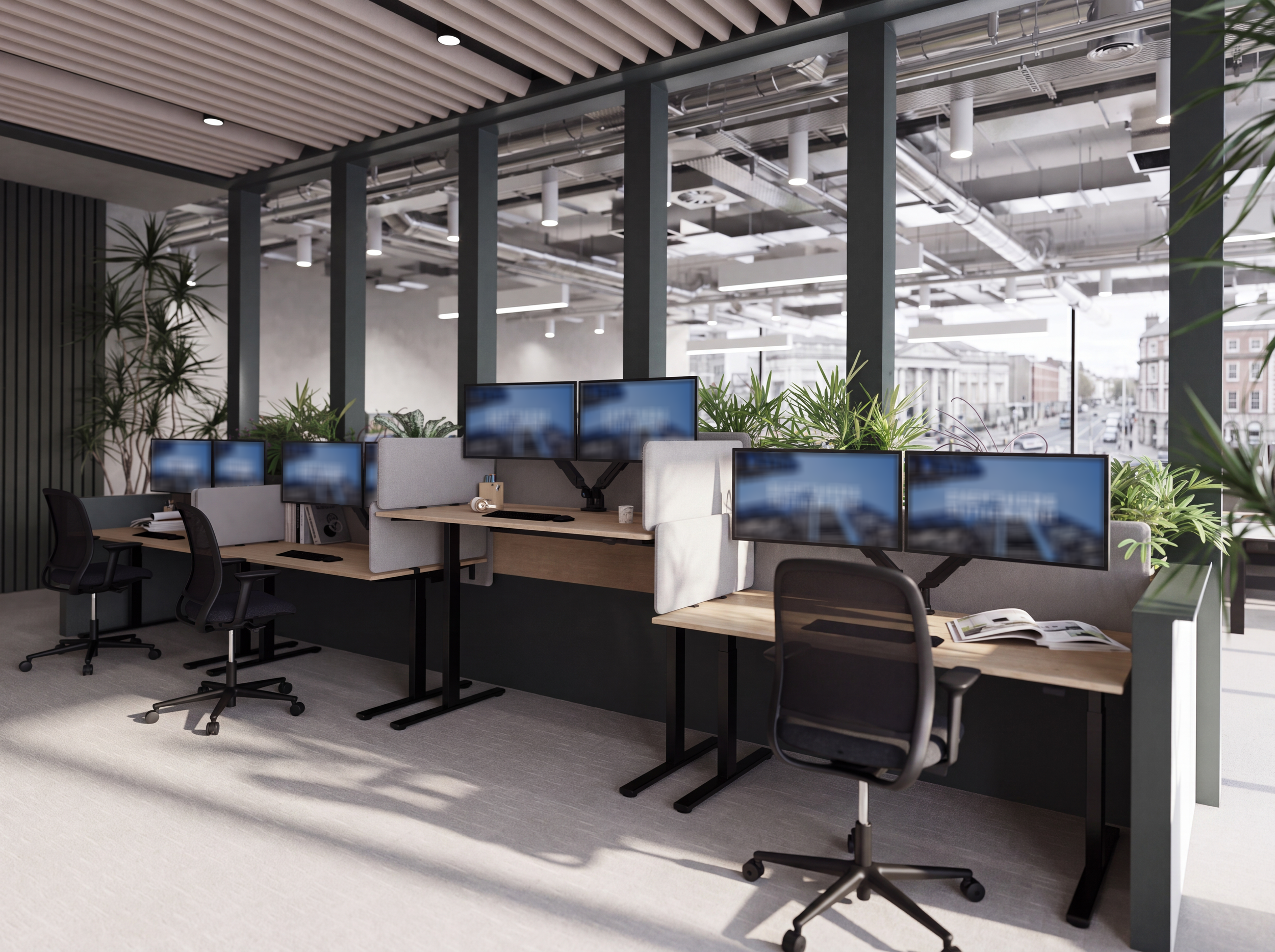 Open-plan modern office with multiple computer workstations, large windows, exposed ceiling pipes, and indoor plants.