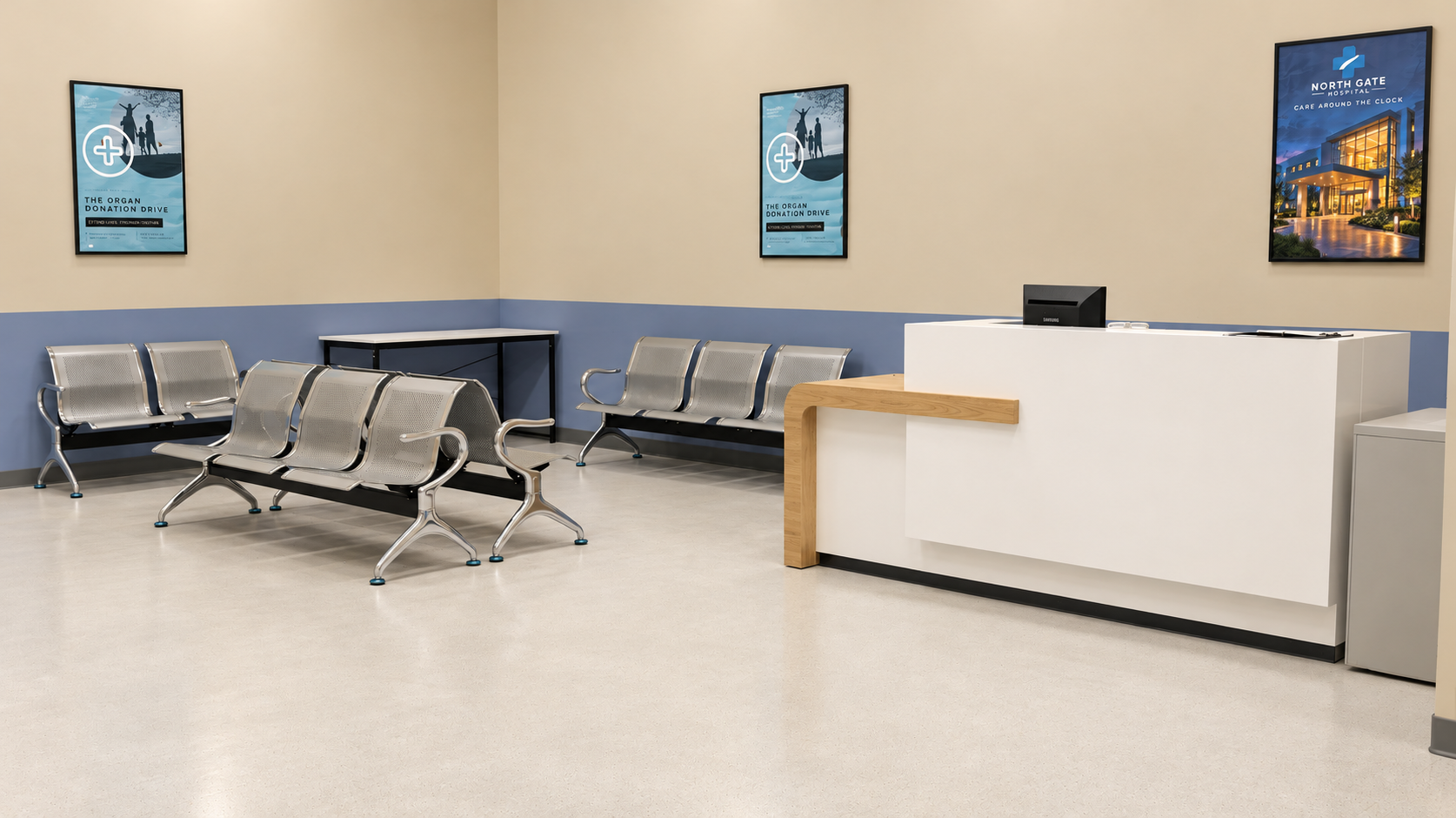 Hospital waiting room with metal chairs, a reception desk, and framed posters on the wall.