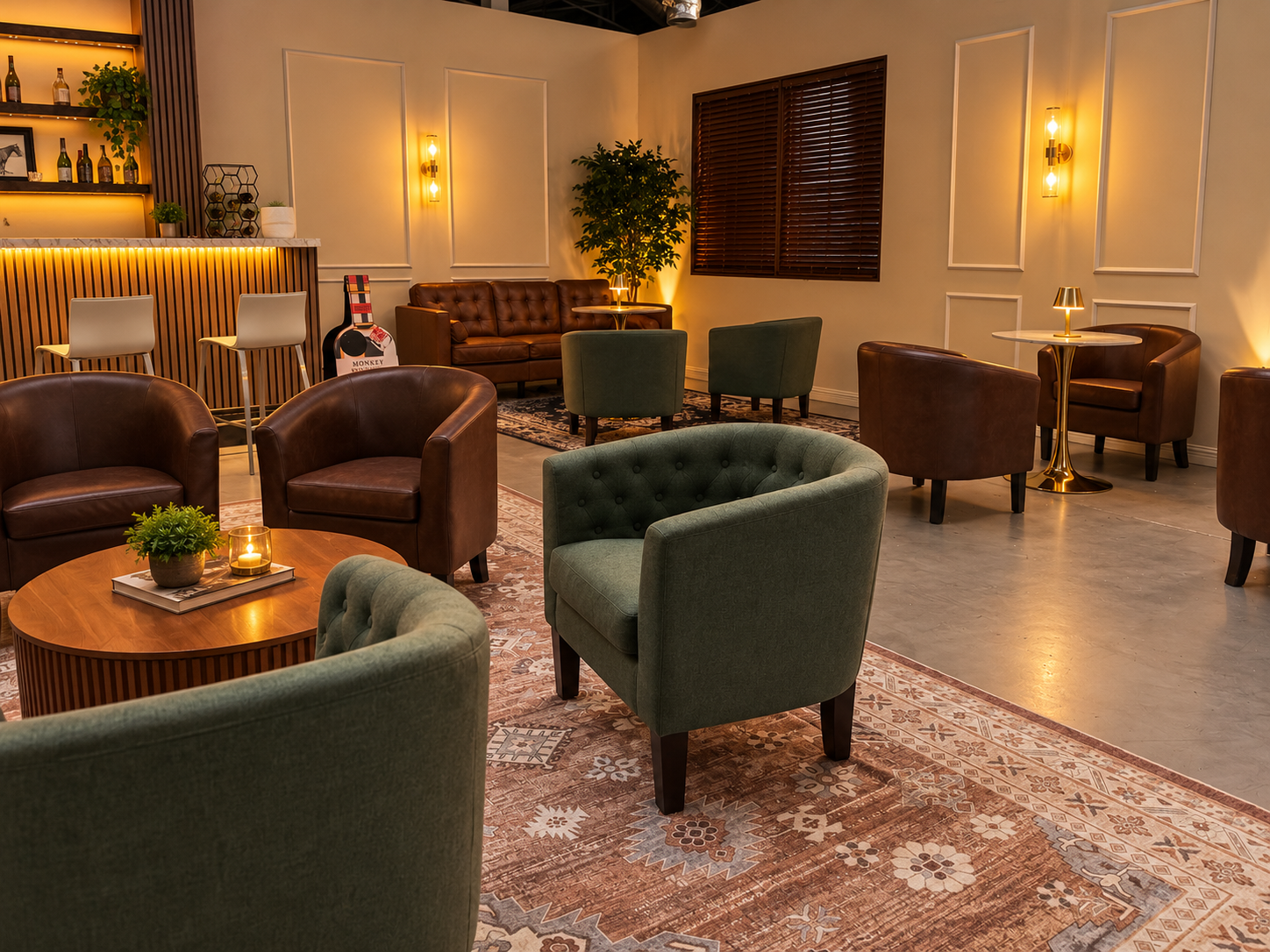 A cozy lounge with green and brown armchairs, sofas, a patterned rug, wooden tables, and warm lighting fixtures.