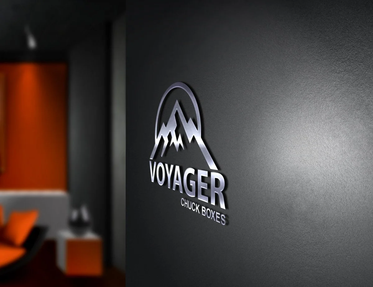 Interior wall with Voyager Chuck Boxes logo featuring mountain peaks in silver on a dark wall.