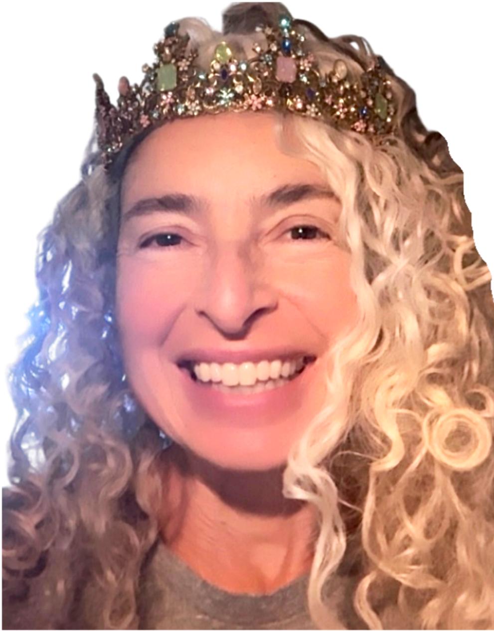 A woman with long, curly blonde hair wearing a colorful jeweled crown and smiling.