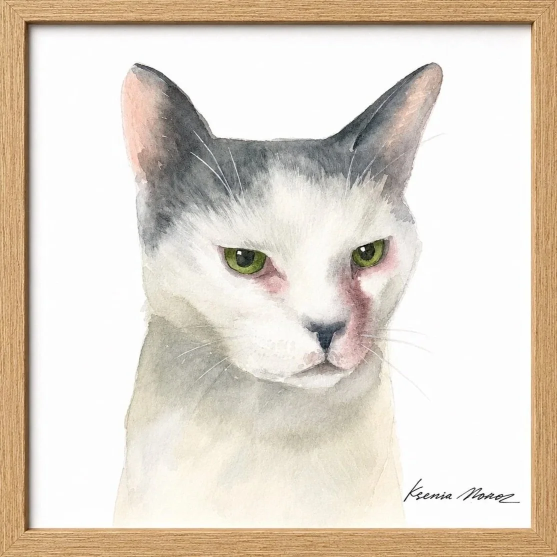 A watercolor painting of a white and gray cat with green eyes, framed in a wooden frame, signed by Keenia Nomez.