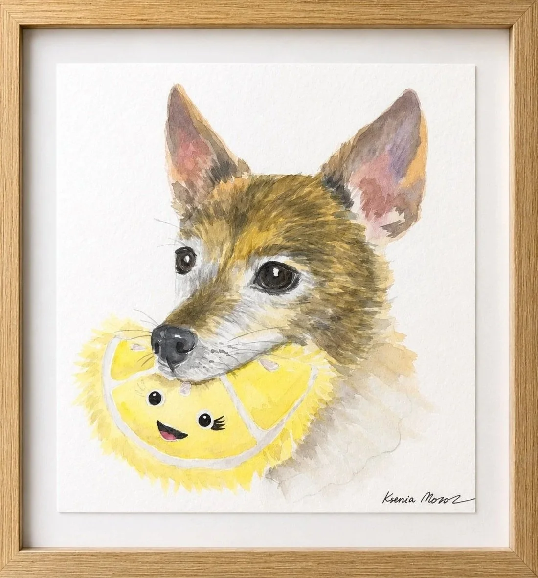 Watercolor painting of a dog holding a yellow plush toy with a smiling face, inside a wooden frame.
