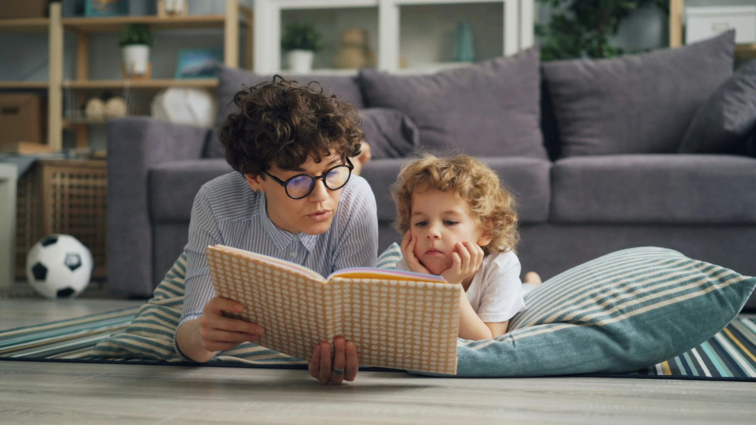 Big brother reading a bedtime story to his eager little sister.