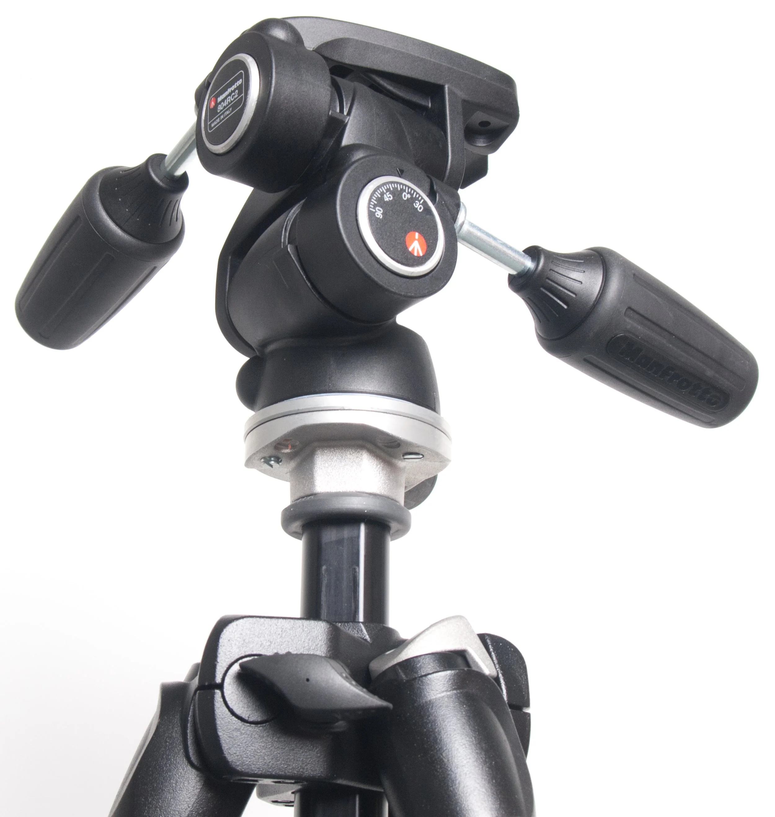 Close-up of the handlebars and steering mechanism of a bicycle, showing the front part with black rubber grips and a central knob with a dial for adjusting the bike's components.