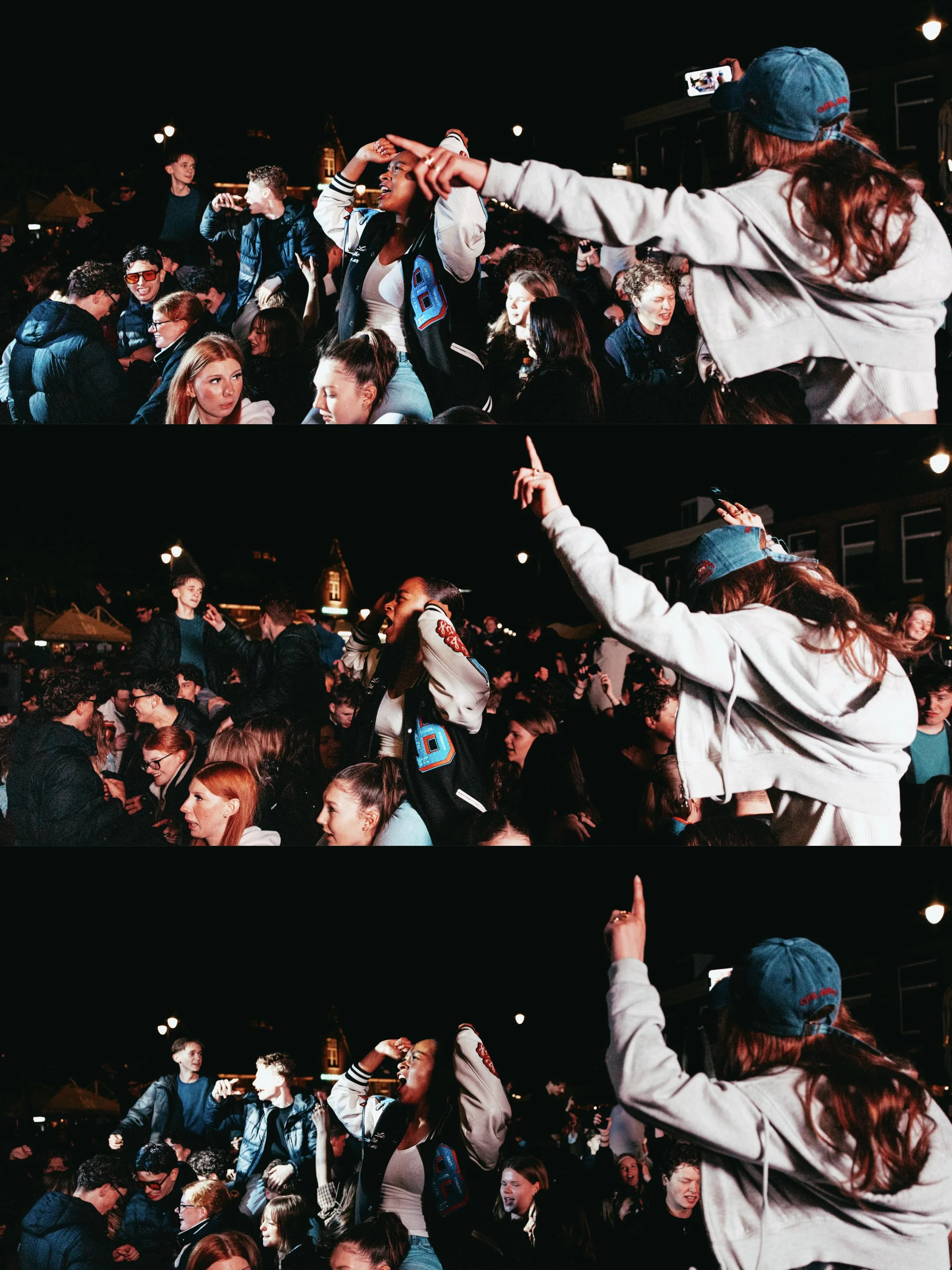 A group of young people dancing and socializing at a nighttime outdoor event with festive lighting in the background.