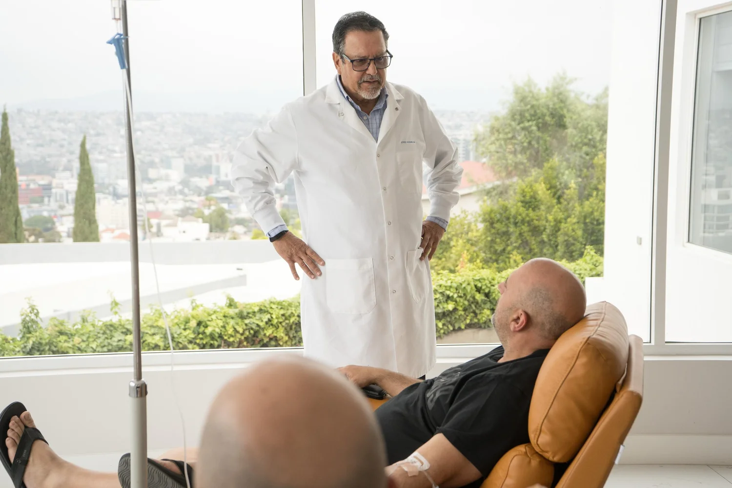 Clinician speaking with a patient in a calm medical setting.