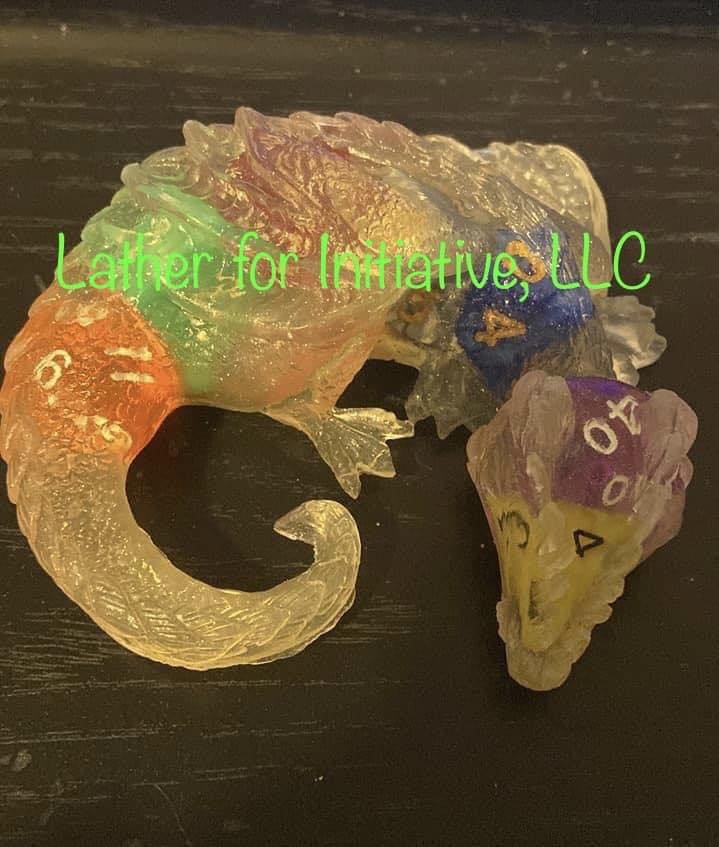 Colorful, translucent plastic sea turtle sculpture with various colored sections, placed on a dark surface, with green text overlay reading "Lather for Initiative, LLC."