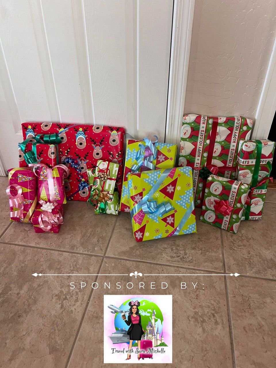 Several wrapped Christmas presents with colorful holiday wrapping paper and ribbons are arranged against a white door and beige wall floor.