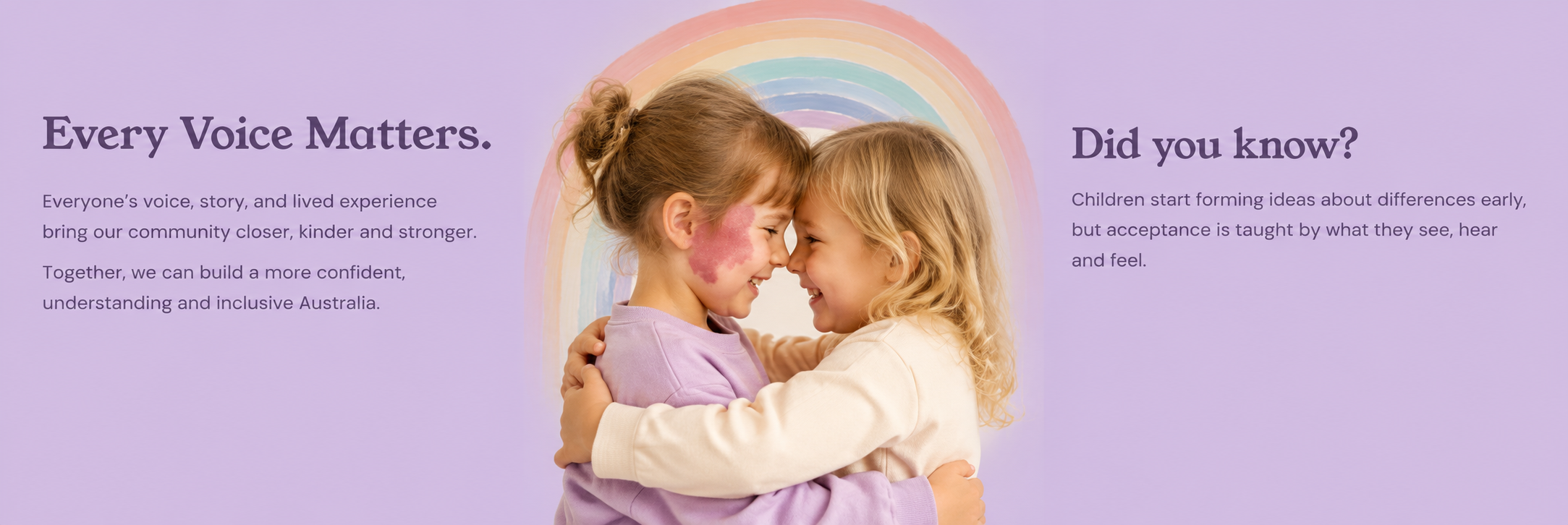 Two young girls smiling and hugging each other, standing in front of a rainbow painted on a purple background.