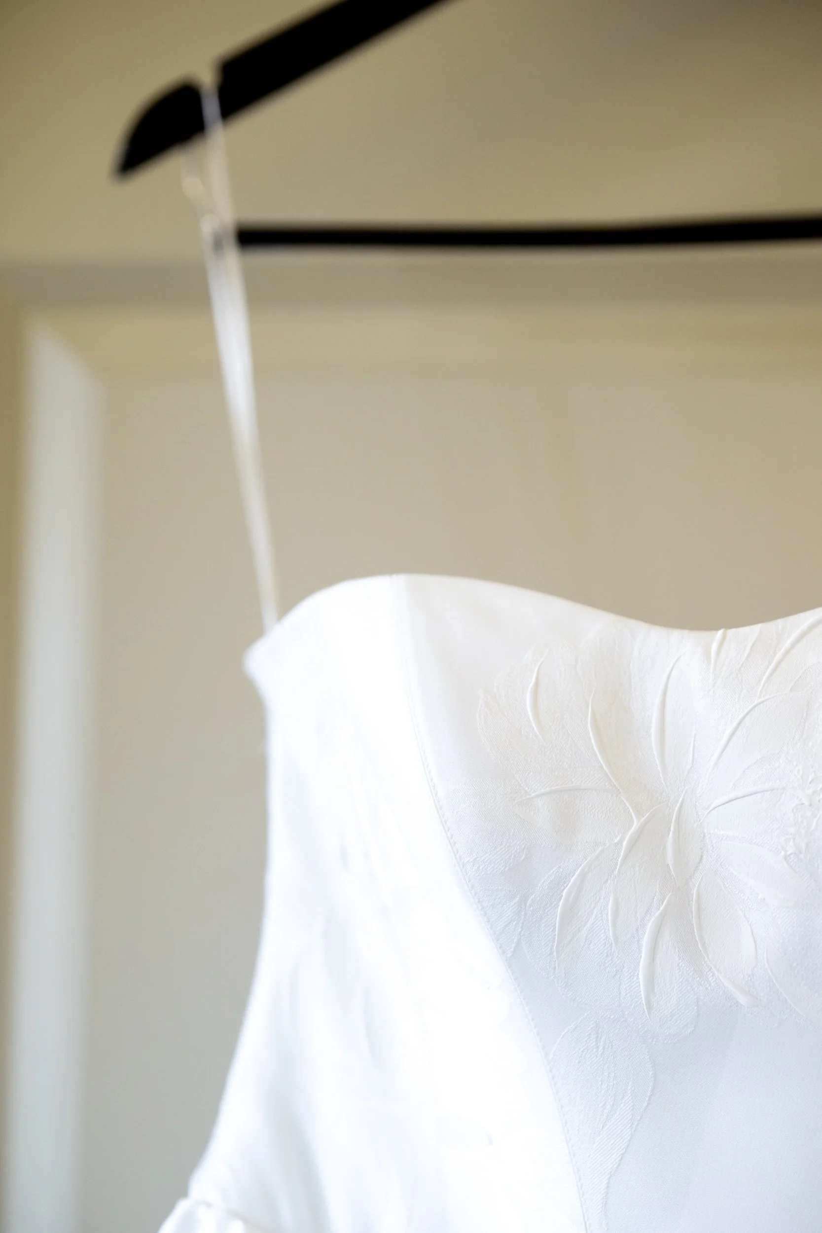 Upgraded wooden hanger displaying a lace wedding gown bodice