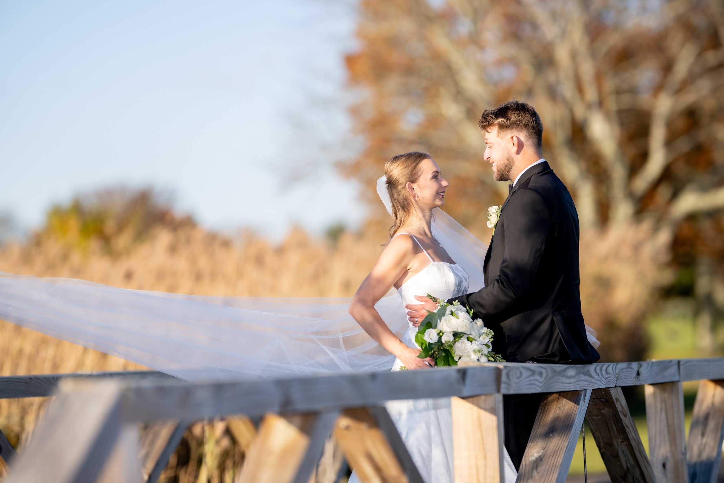 Newlyweds sharing a candid moment during an outdoor coastal wedding in Narragansett, Rhode Island. Captured by Allison Mott of Mott Collective.