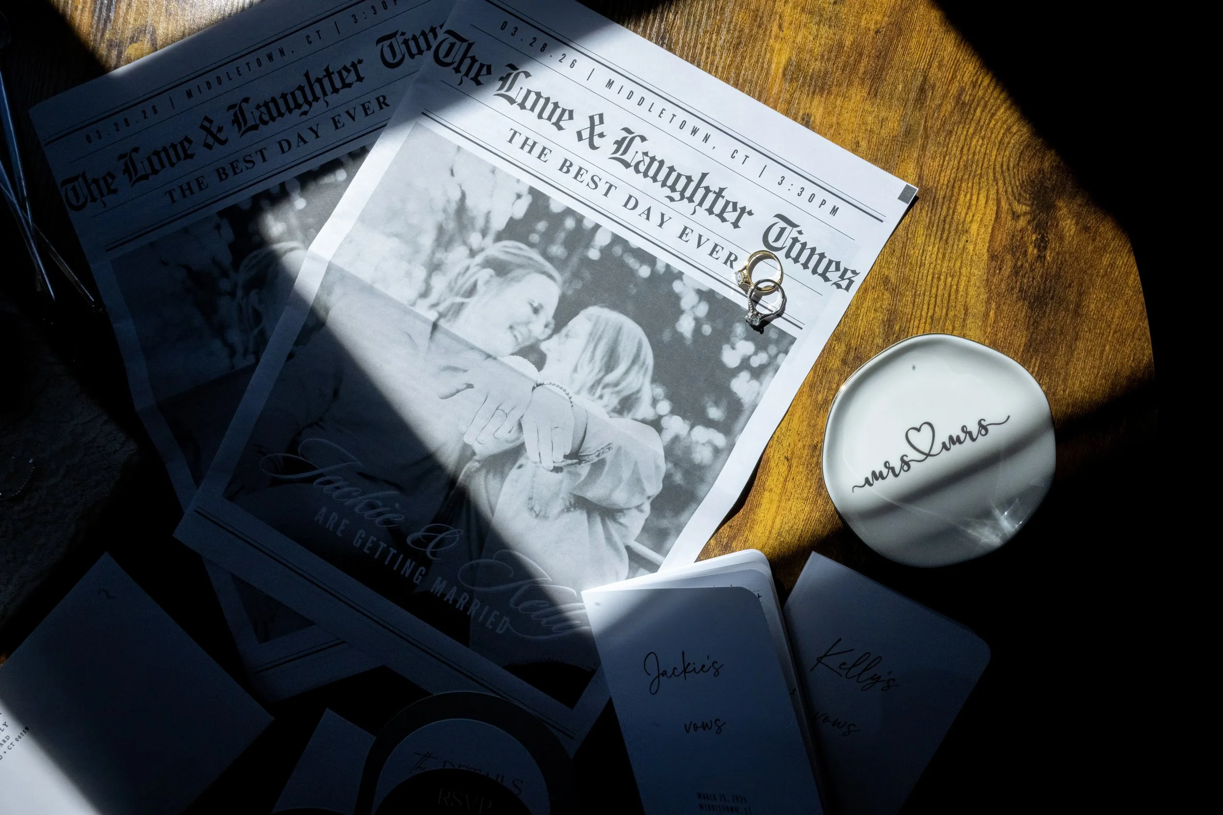 A blurred image showing a jewelry ring and a magazine titled 'The Observer' on a surface with a bubble pattern, with a gold wall in the background.
