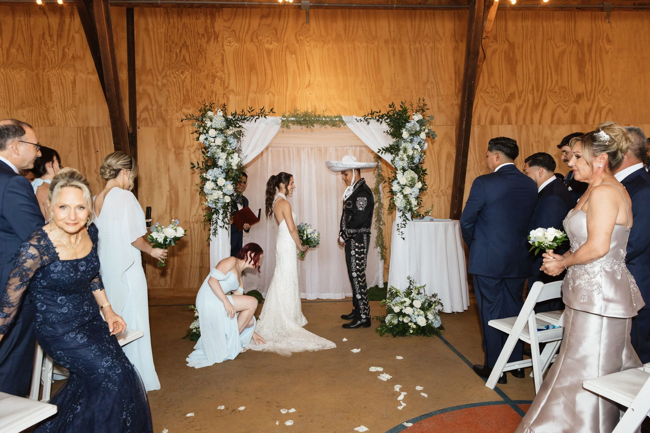 A wedding ceremony with the couple exchanging vows, surrounded by family and friends in a decorated venue.
