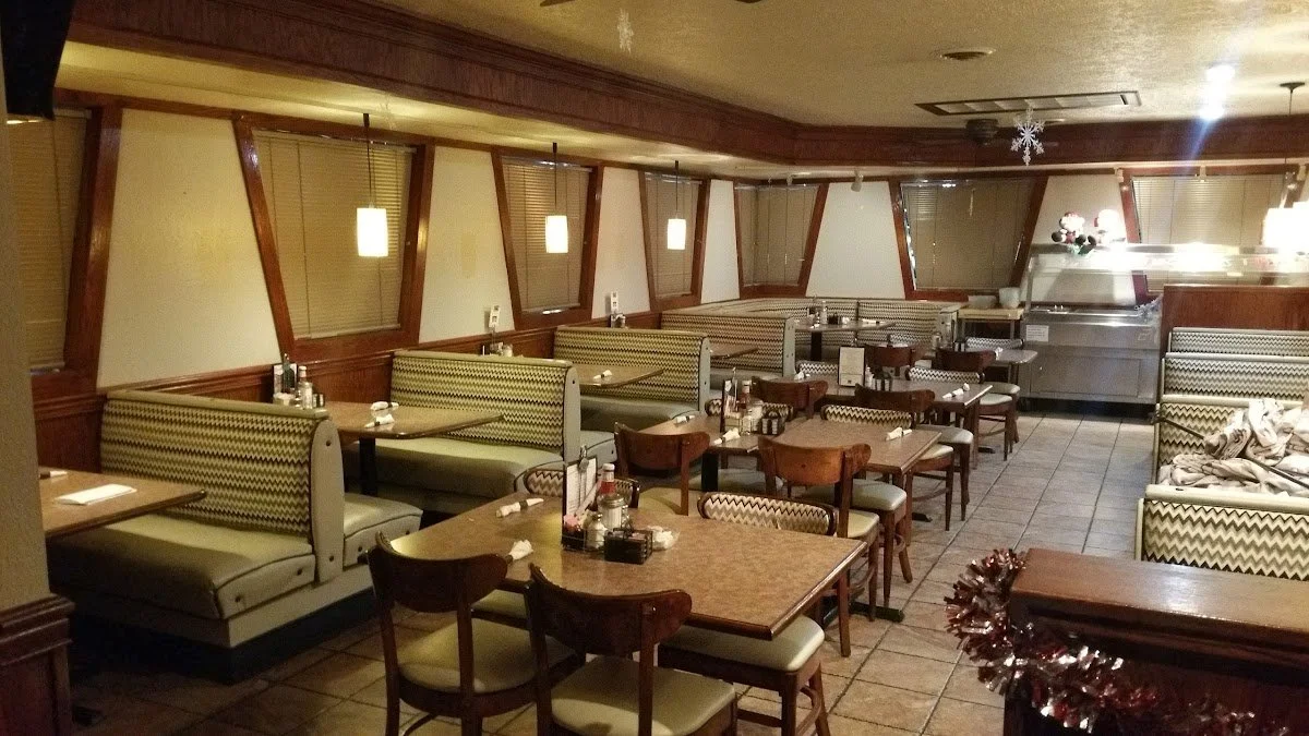 Empty restaurant dining area with booths and tables, Christmas decorations, and a buffet station at the back.