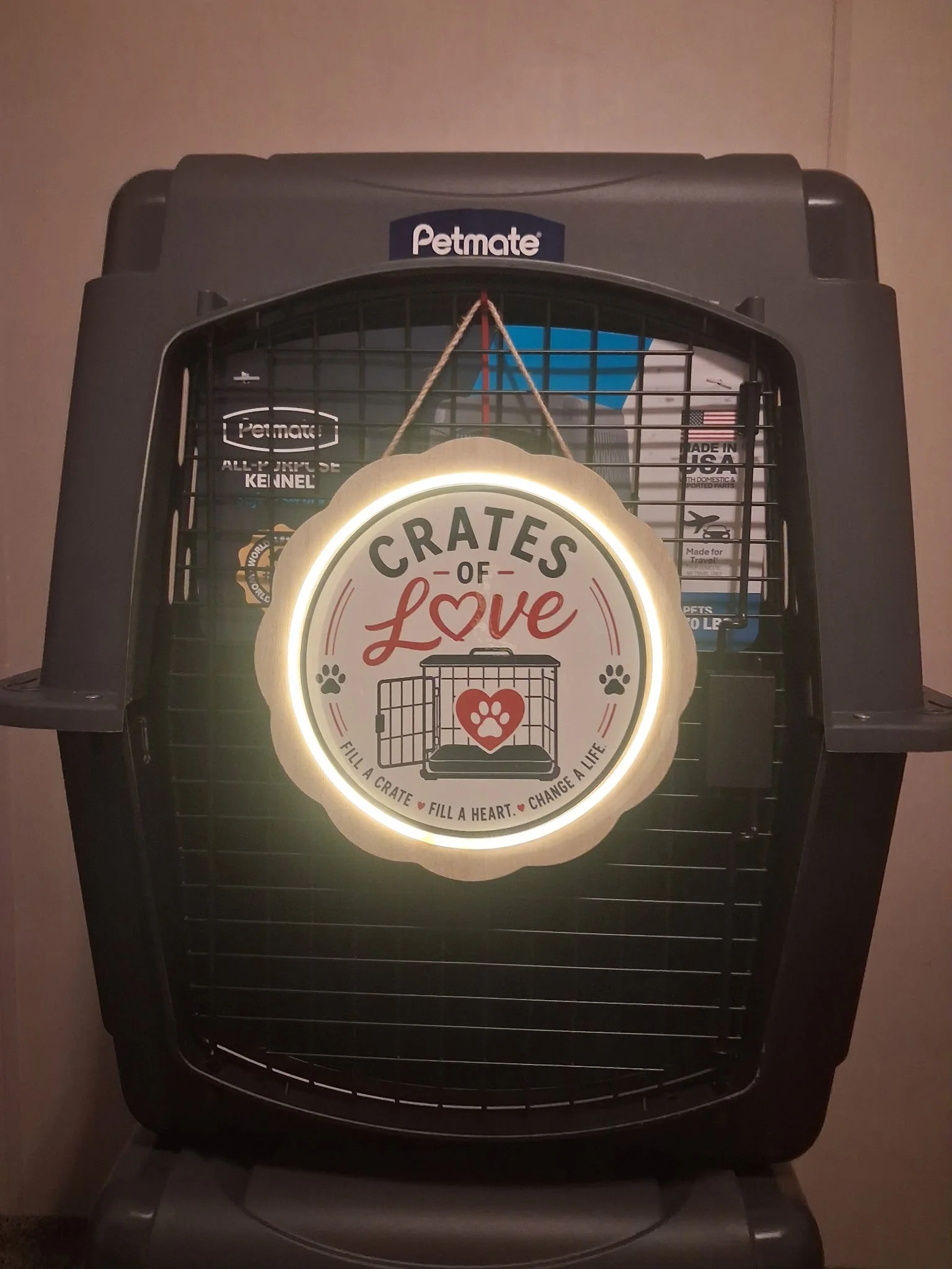 Pet crate with a illuminated sign that reads 'Crates of Love' and a paw print, cage design, and heart graphic.