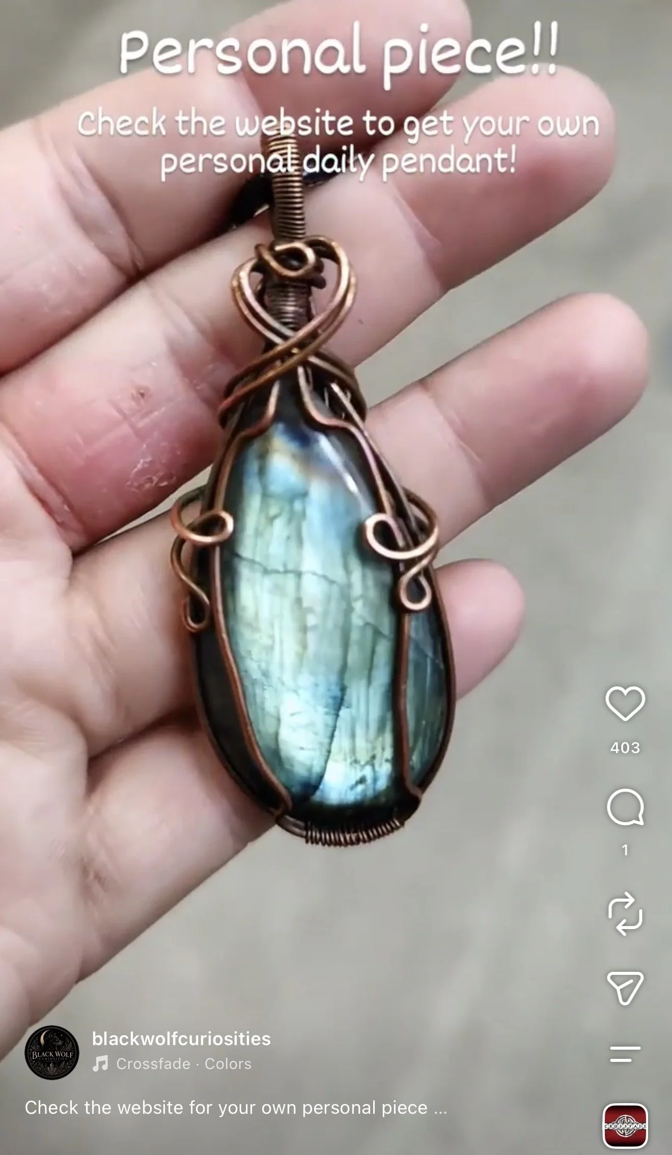 Close-up of a hand holding a wire-wrapped pendant with an iridescent blue-green stone. Text overlay says 'Personal piece!! Check the website to get your own personal daily pendant!'