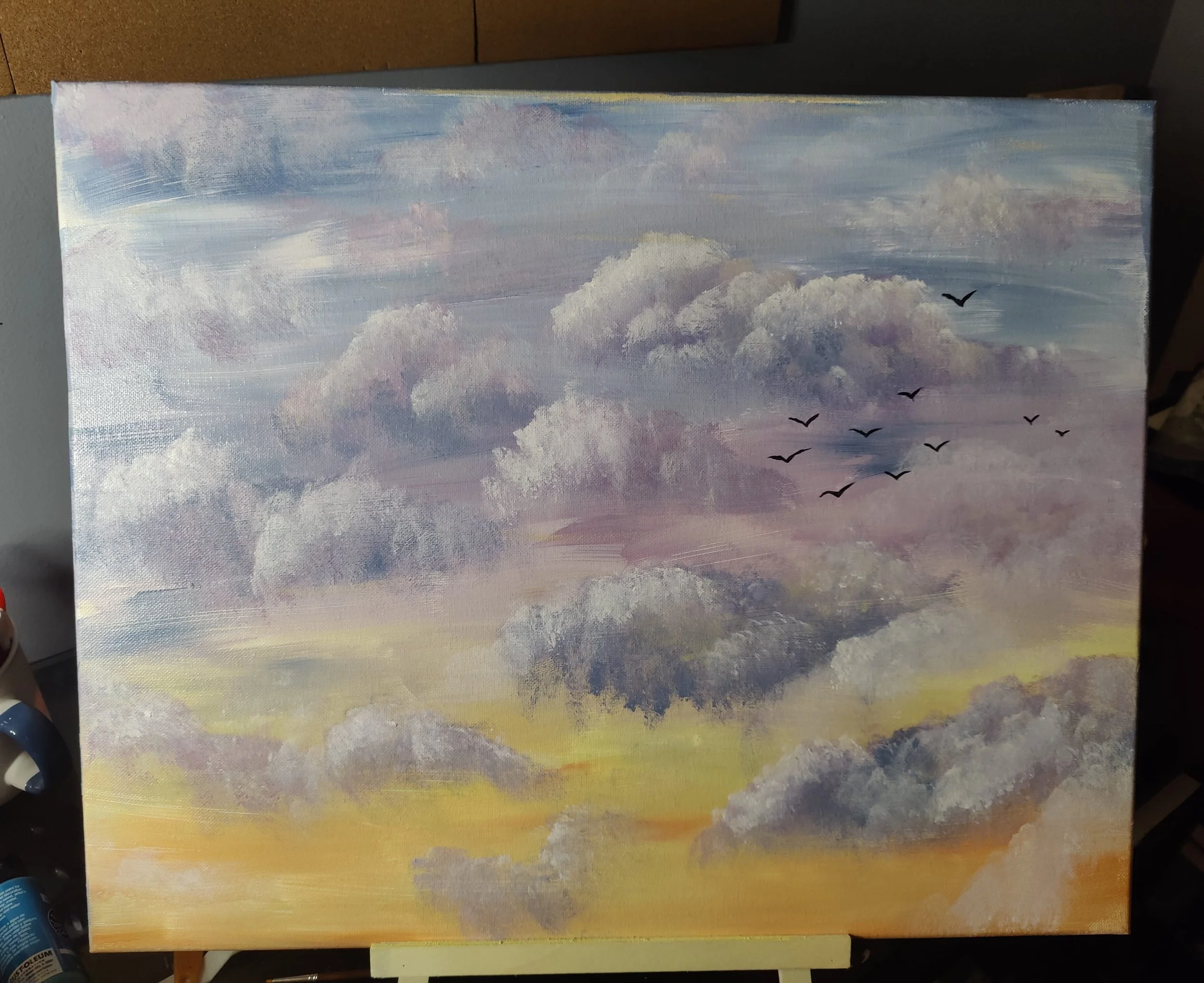 A painting of a cloudy sky with birds flying in the distance