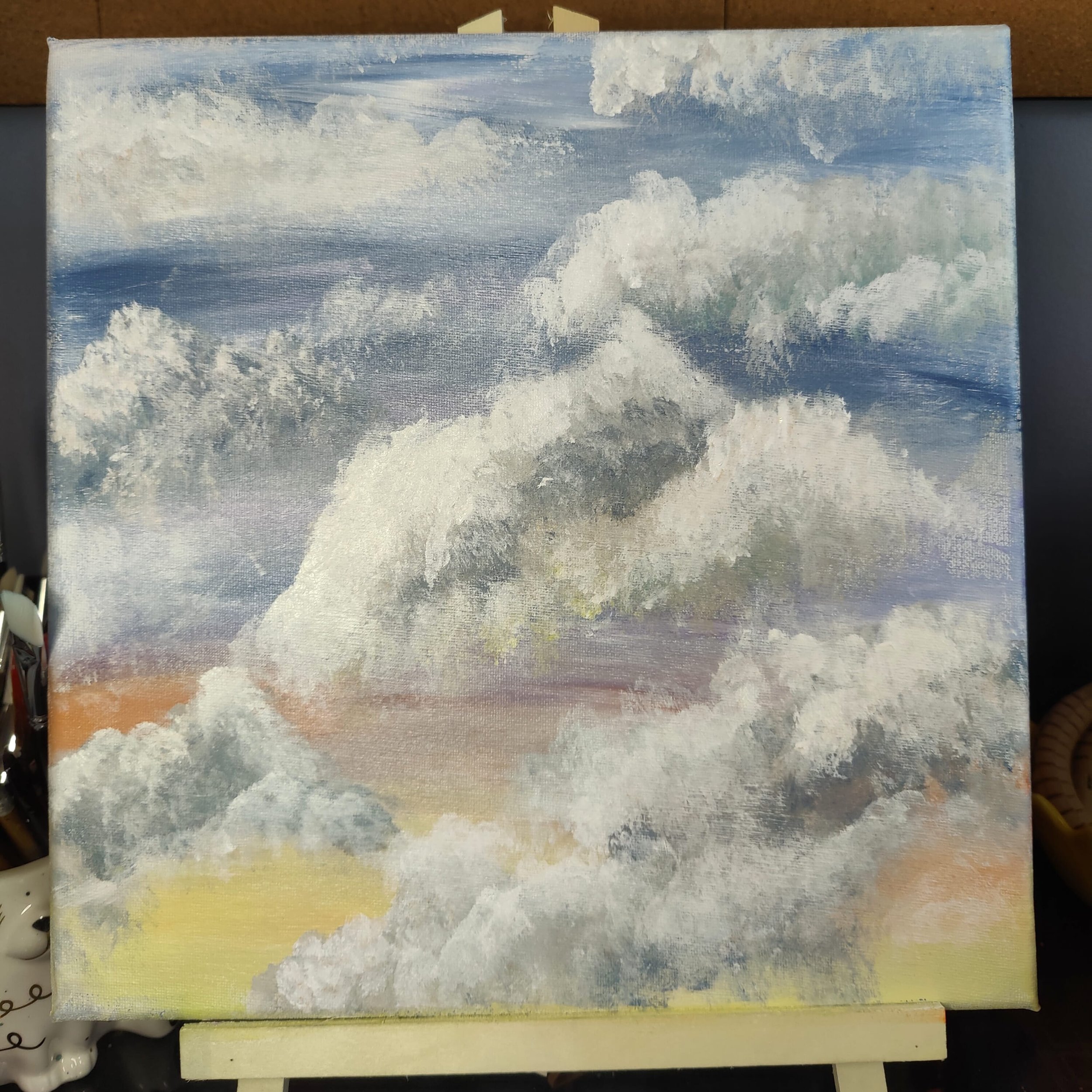 A painting of clouds in a blue sky with some hints of yellow near the horizon.