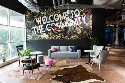 Welcome to the community sign in modern lounge with sofa, armchair, side tables, plants, and window views
