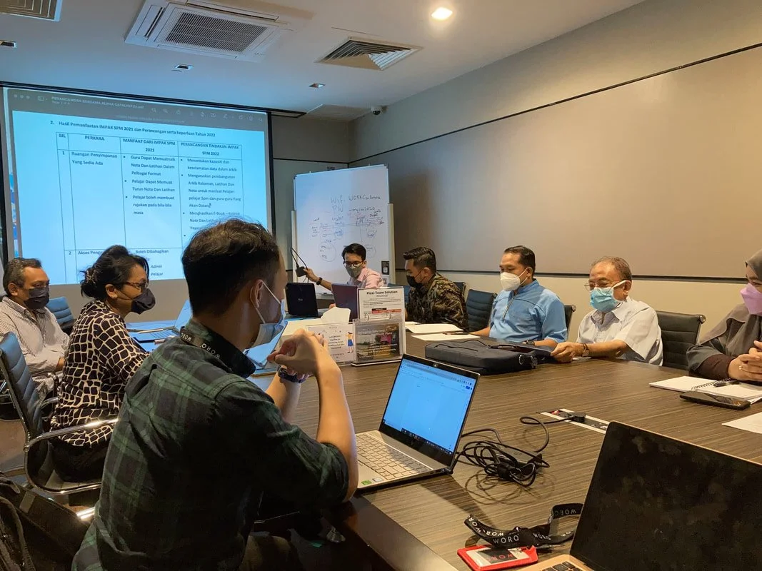 A group of professionals in a meeting room reviewing data and discussing