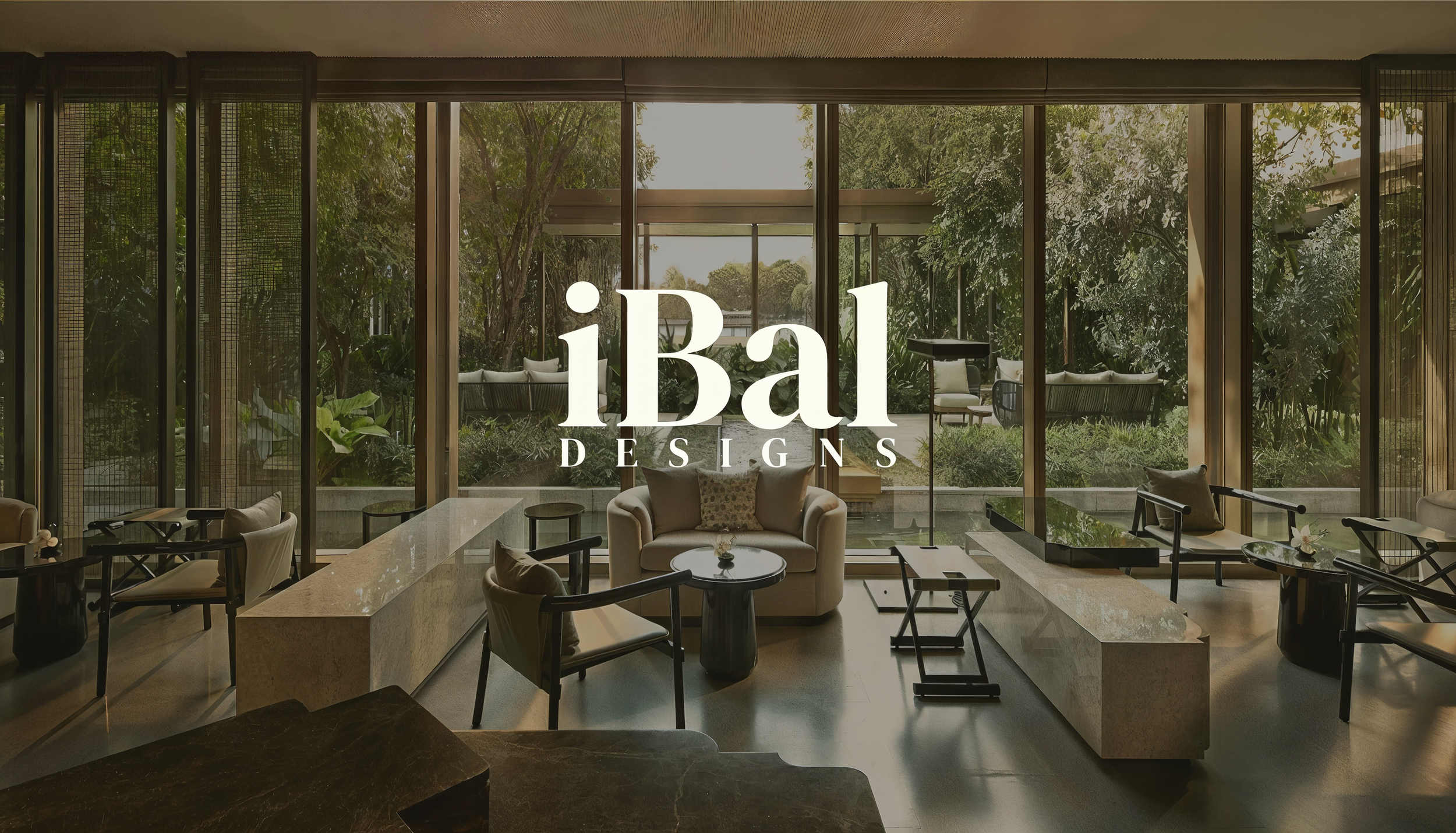 Interior of a modern lounge with large floor-to-ceiling windows revealing lush green trees outside. The space features seating with armchairs, sofas, and small tables, alongside decorative plants and a vibrant atmosphere. The logo 'iBal DESIGNS' is prominently displayed in the center.