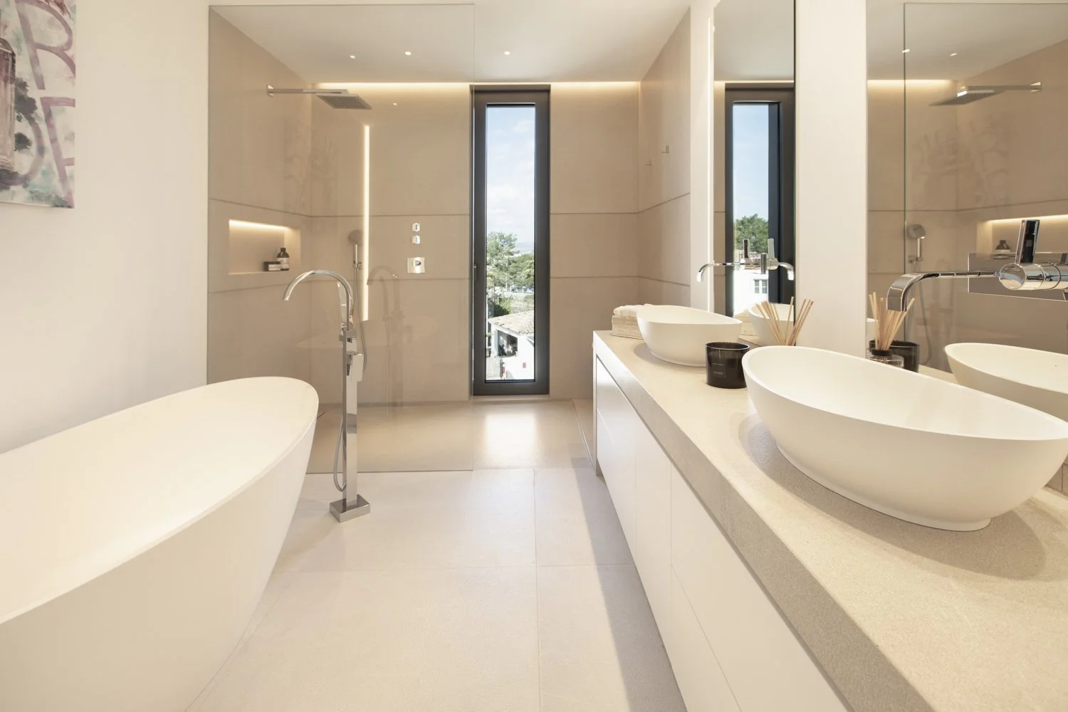 Baño moderno con bañera de pie, dos lavabos en encimera y ducha tras cristal transparente.