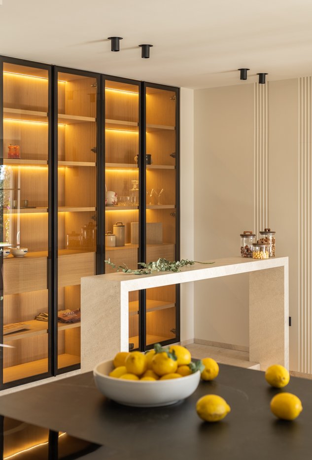 Mostrador de cocina con limones en un tazón y frascos de ingredientes secos en una encimera