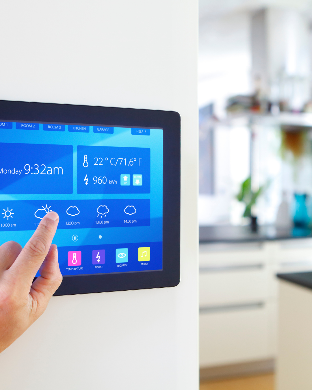Persona tocando una pantalla digital en la pared, que muestra información sobre temperatura, clima, hora y energía en una casa moderna, en una cocina bien iluminada.