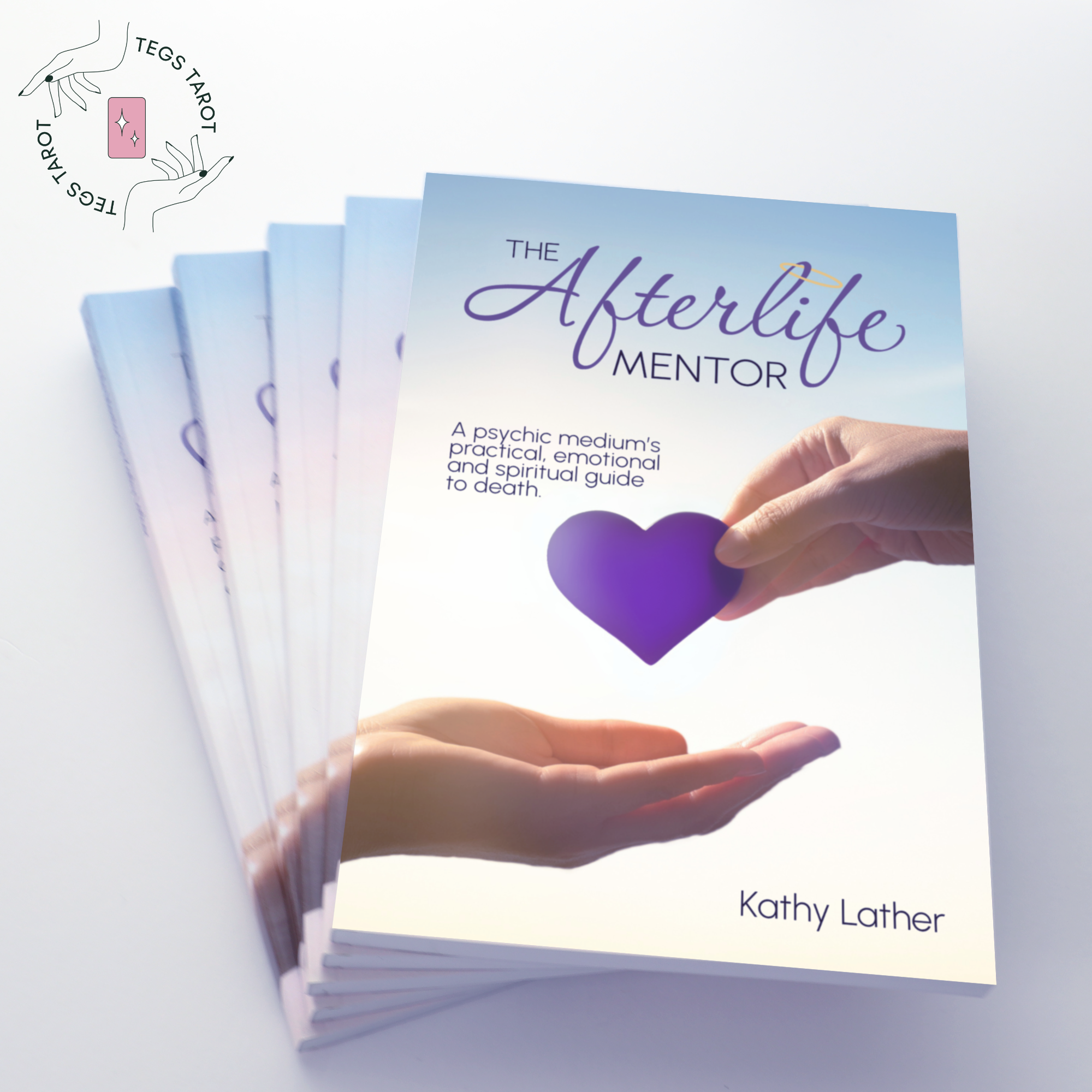 The Afterlife Mentor book by Kathy Lather fanned out. The cover image is a hand holding out a purple heart to another.