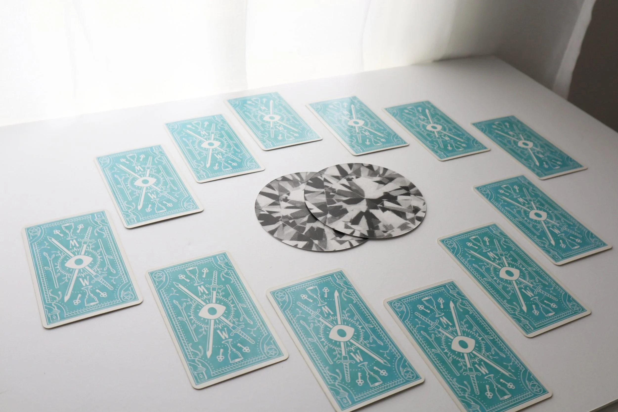 12 card spread, 12 Tarot cards face down surround 2 oracle cards in the centre of the image