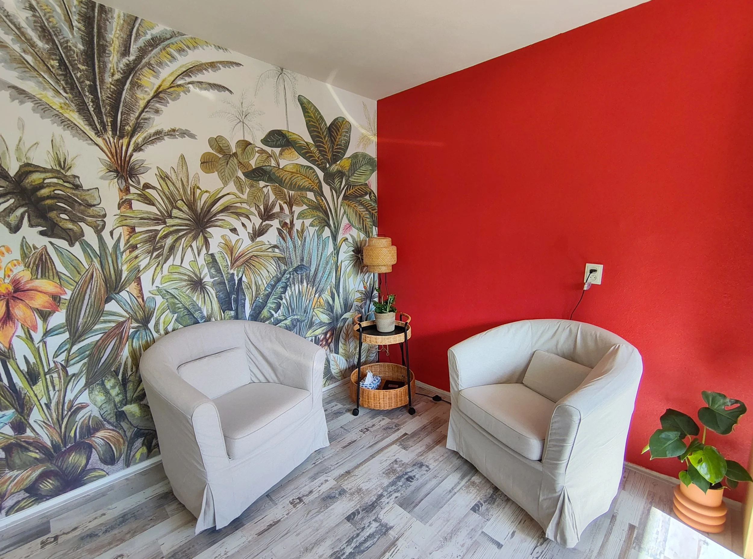 De coachruimte van Bloei & Kracht in Deventer: twee fauteuils, botanisch behang en een warme rode wand