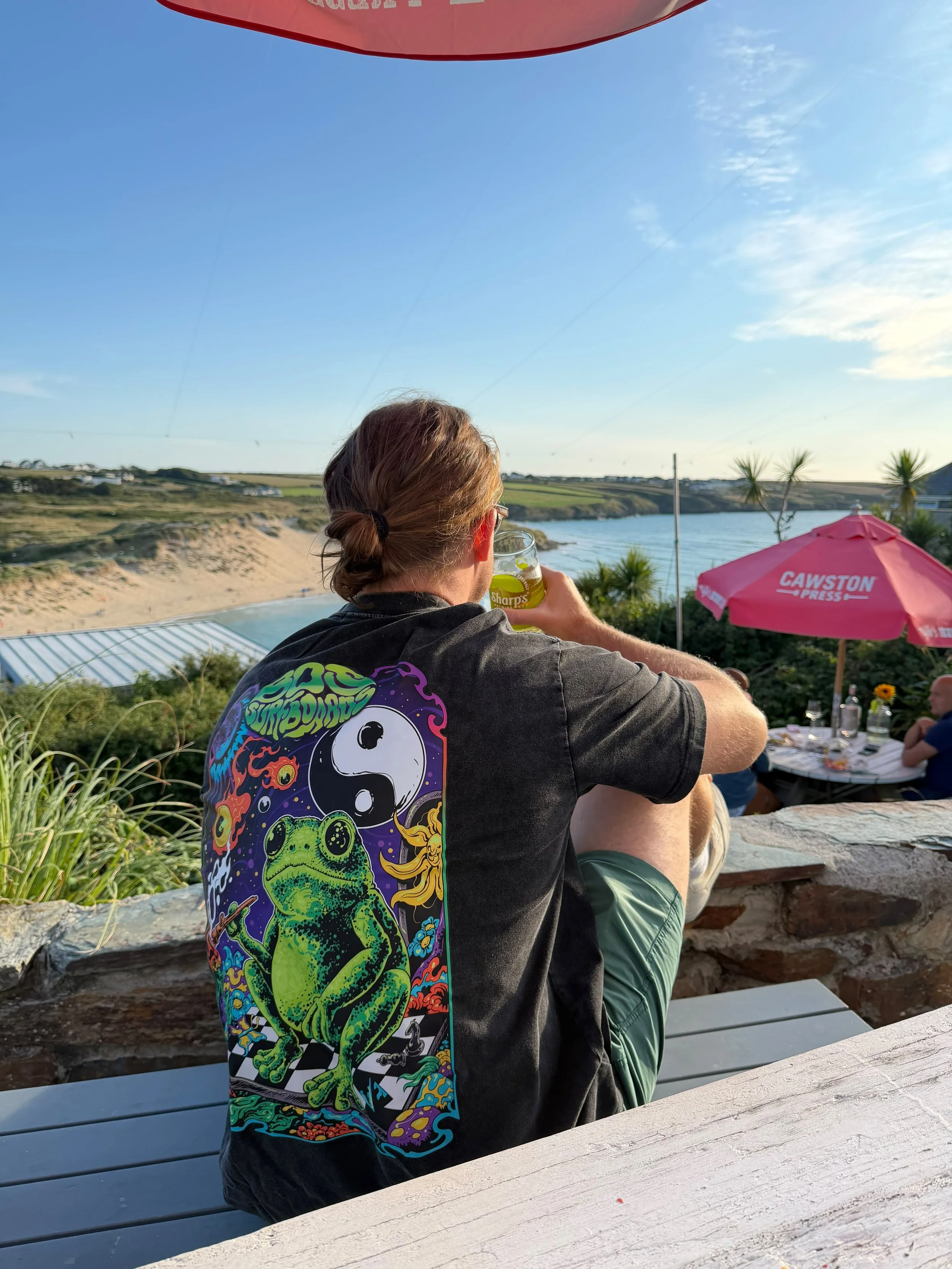 Guest enjoying a drink overlooking a Cornwall beach and the Gannel estuary.
