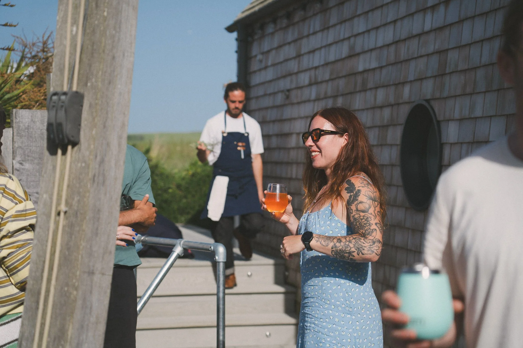 Guest holding a drink outside the Peak retreat house in Cornwall.
