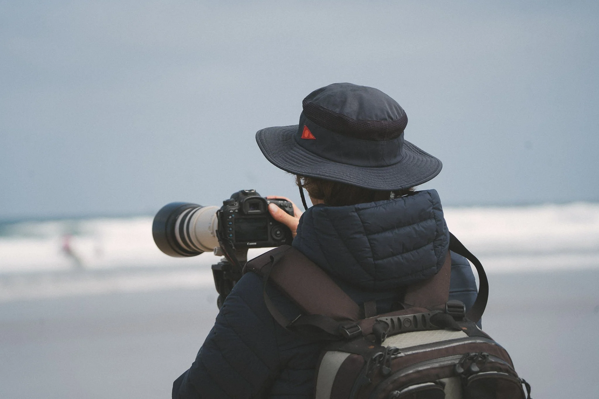 Photographer filming surf coaching from the shore in Cornwall for advanced surf coaching lesson.