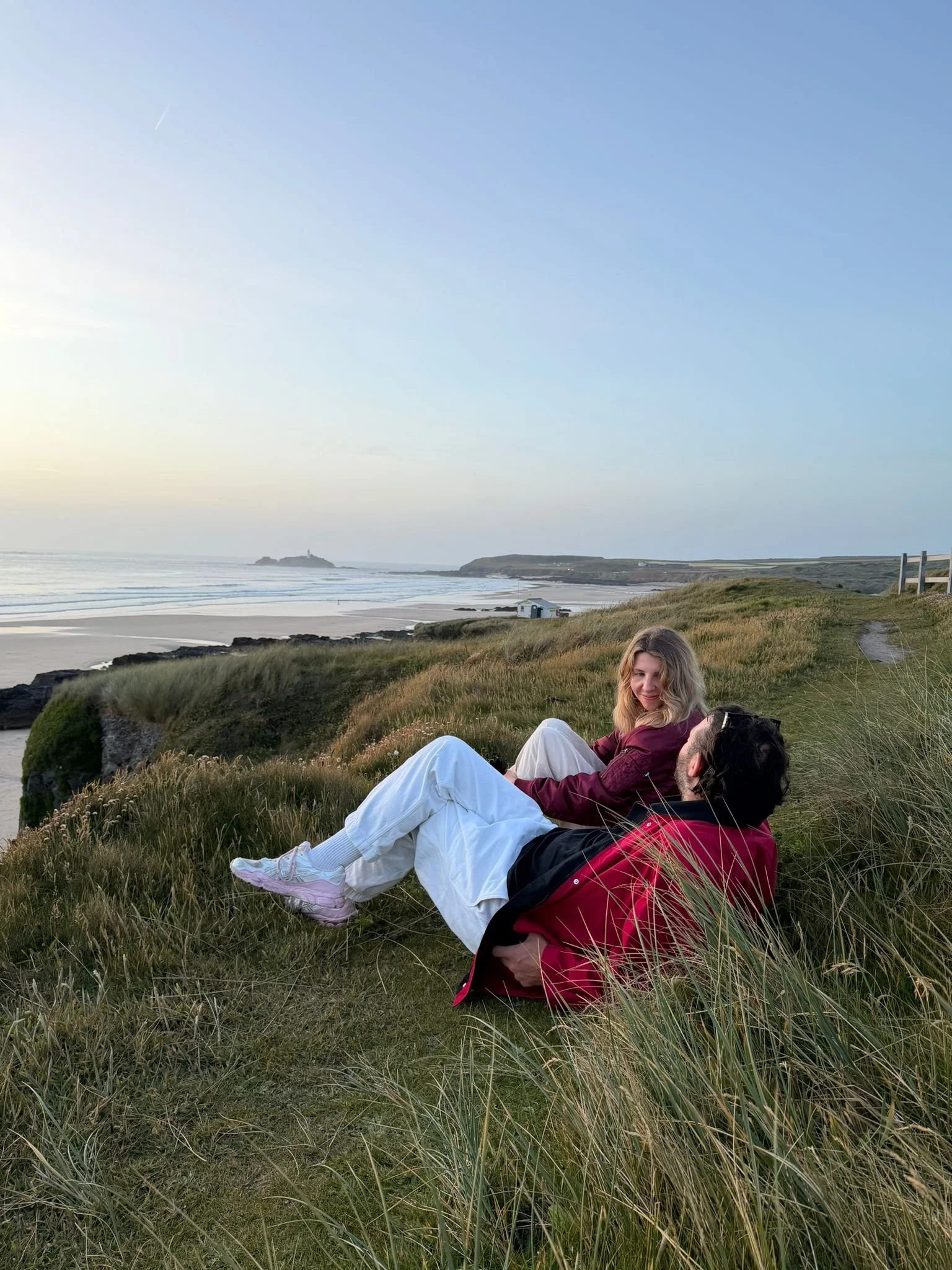 two guests at Peak surf retreat watching the sunset over Godrevy lighthouse