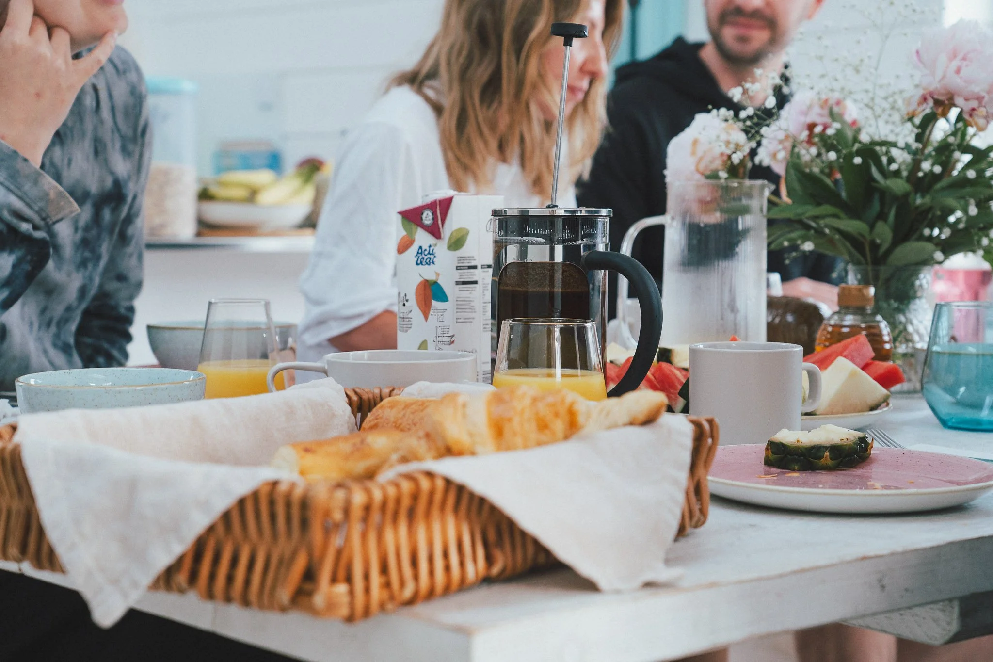 Guests sharing breakfast with fresh bread, fruit and coffee at the retreat.