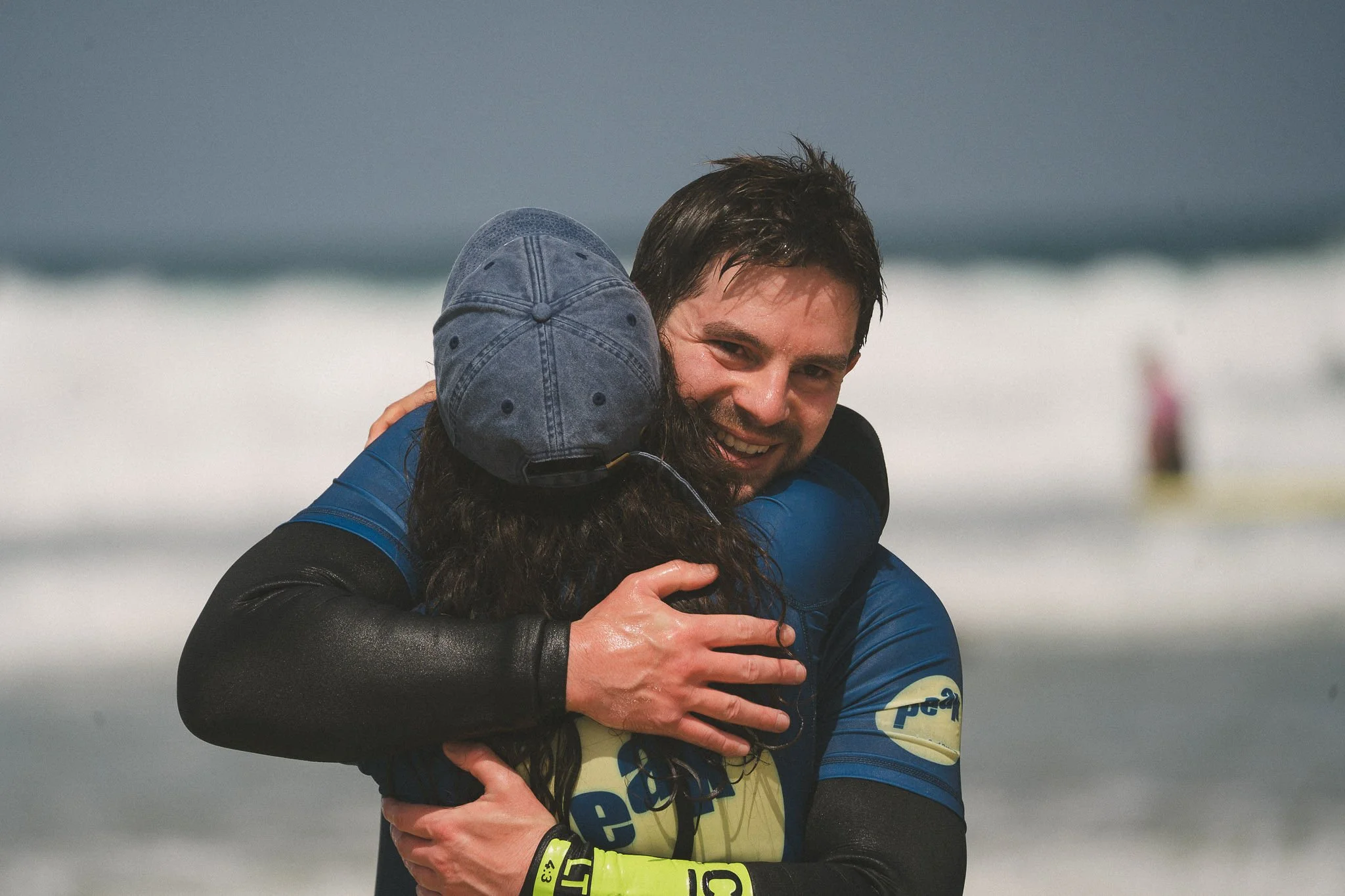 a guest at Peak surf retreat hugging the founder after a great surf lesson.