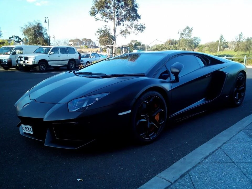 Black Lamborghini parked at a Cannonball Run Australia rally checkpoint