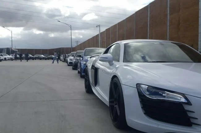 White Audi R8 leading a line of cars on the rally route
