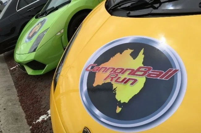 Yellow supercar and green Lamborghini branded for Cannonball Run Australia