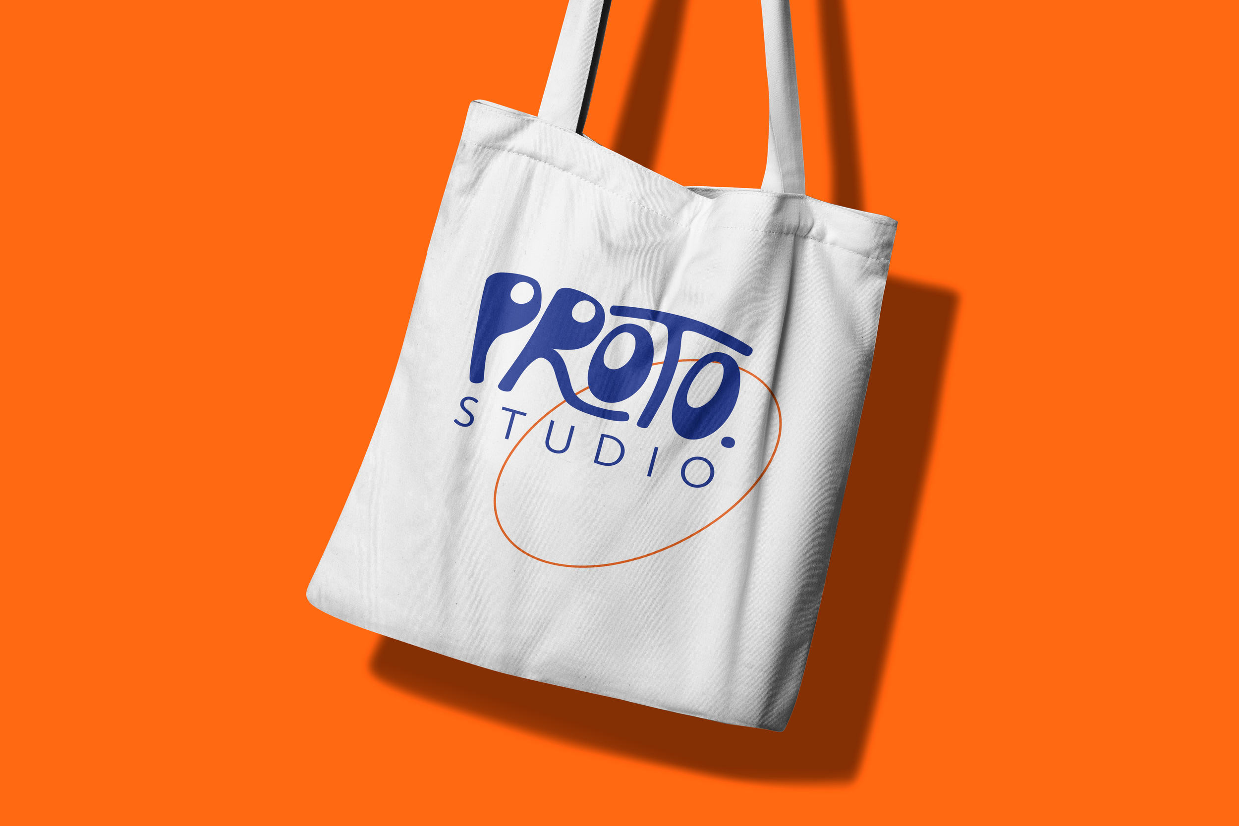 White tote bag with 'Proto. Studio' logo on an orange background.